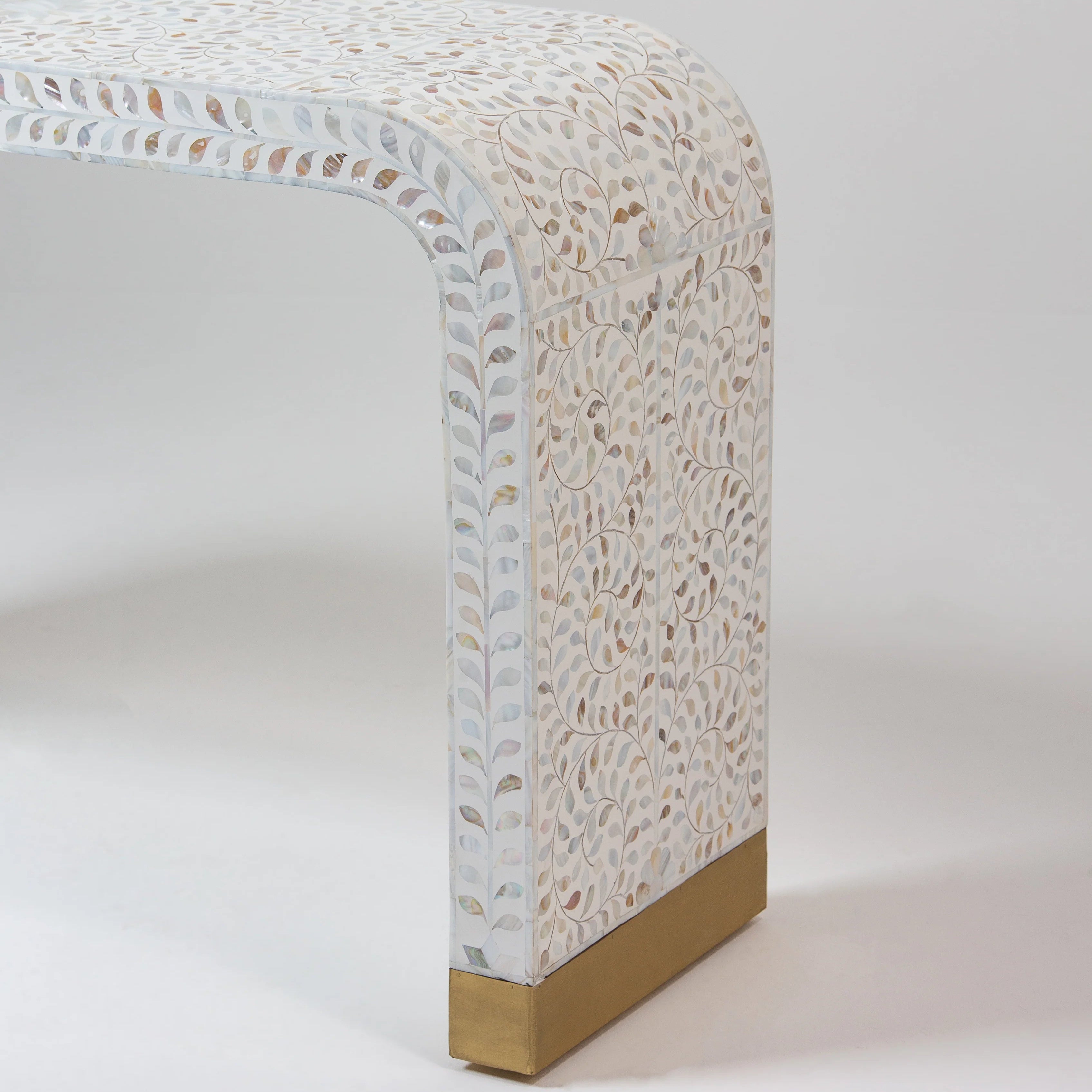 Close-up of a beautifully crafted bone inlay side table with intricate leaf patterns and a brass base.