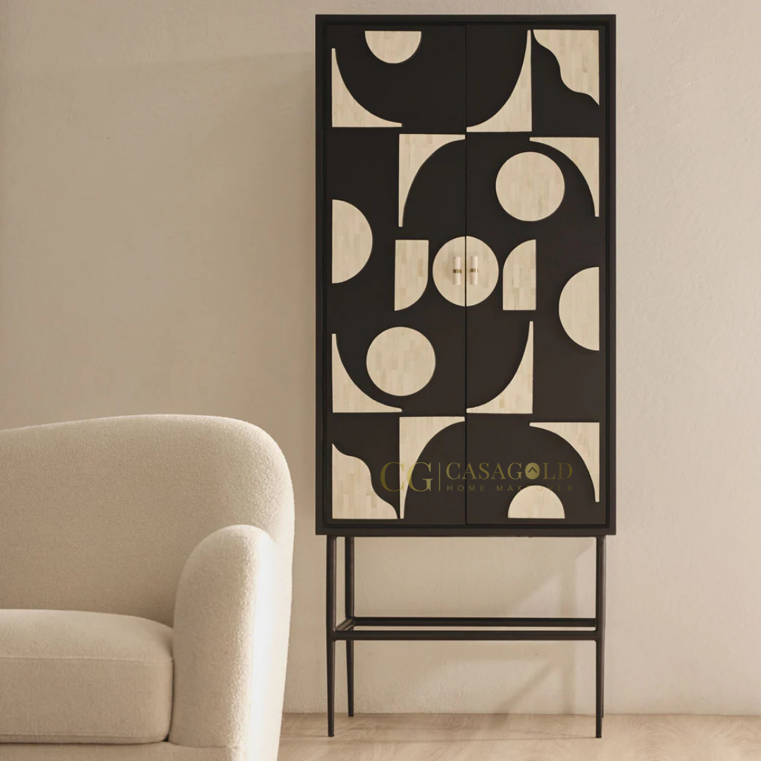 Tall black cabinet with abstract cream geometric patterns next to a plush cream armchair.
