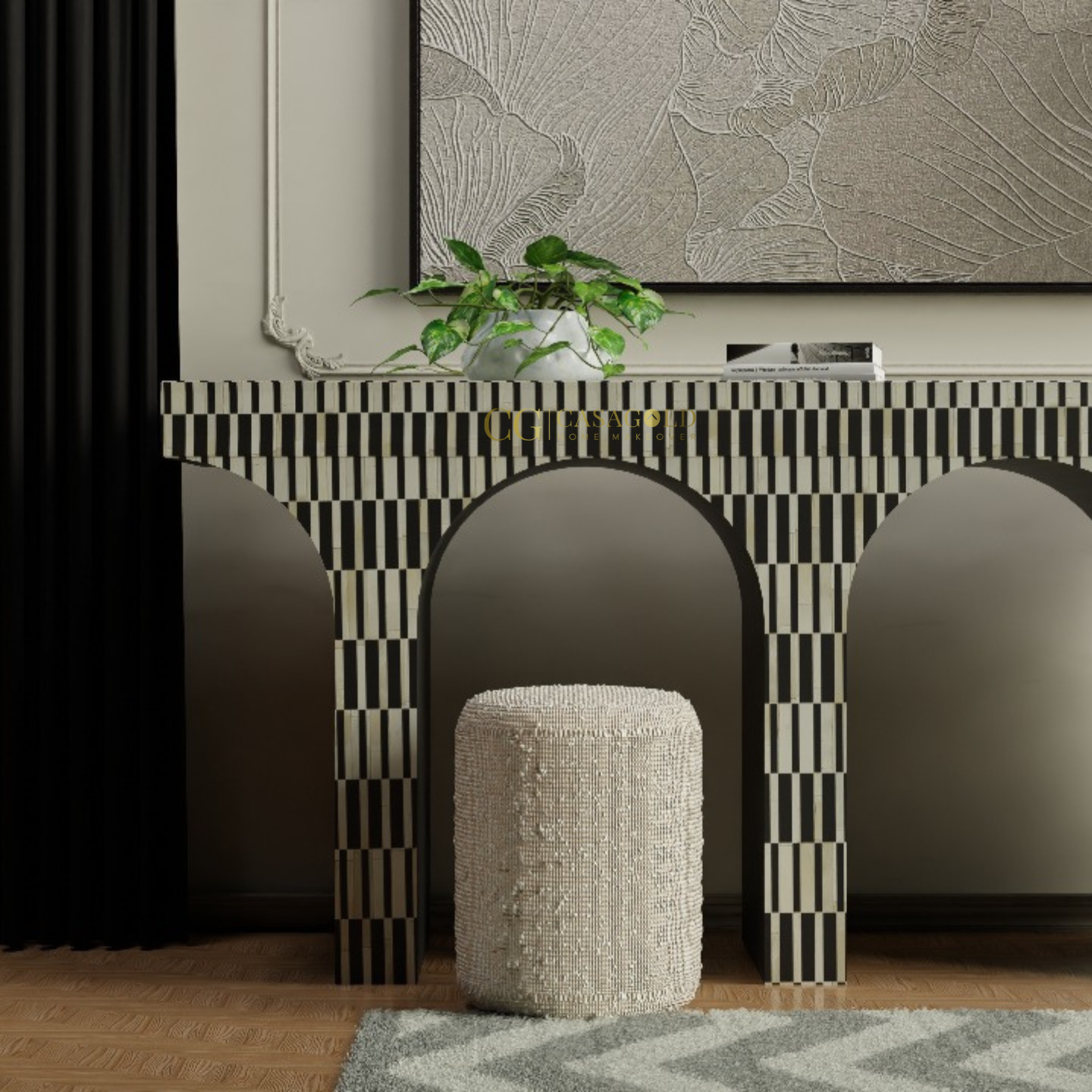 Black and white arched console table with a modern art piece and a small plant on top