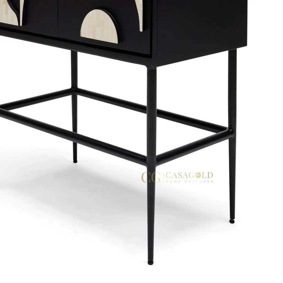 Artistic storage piece with high-contrast black and cream pattern, elevated on slim black legs.