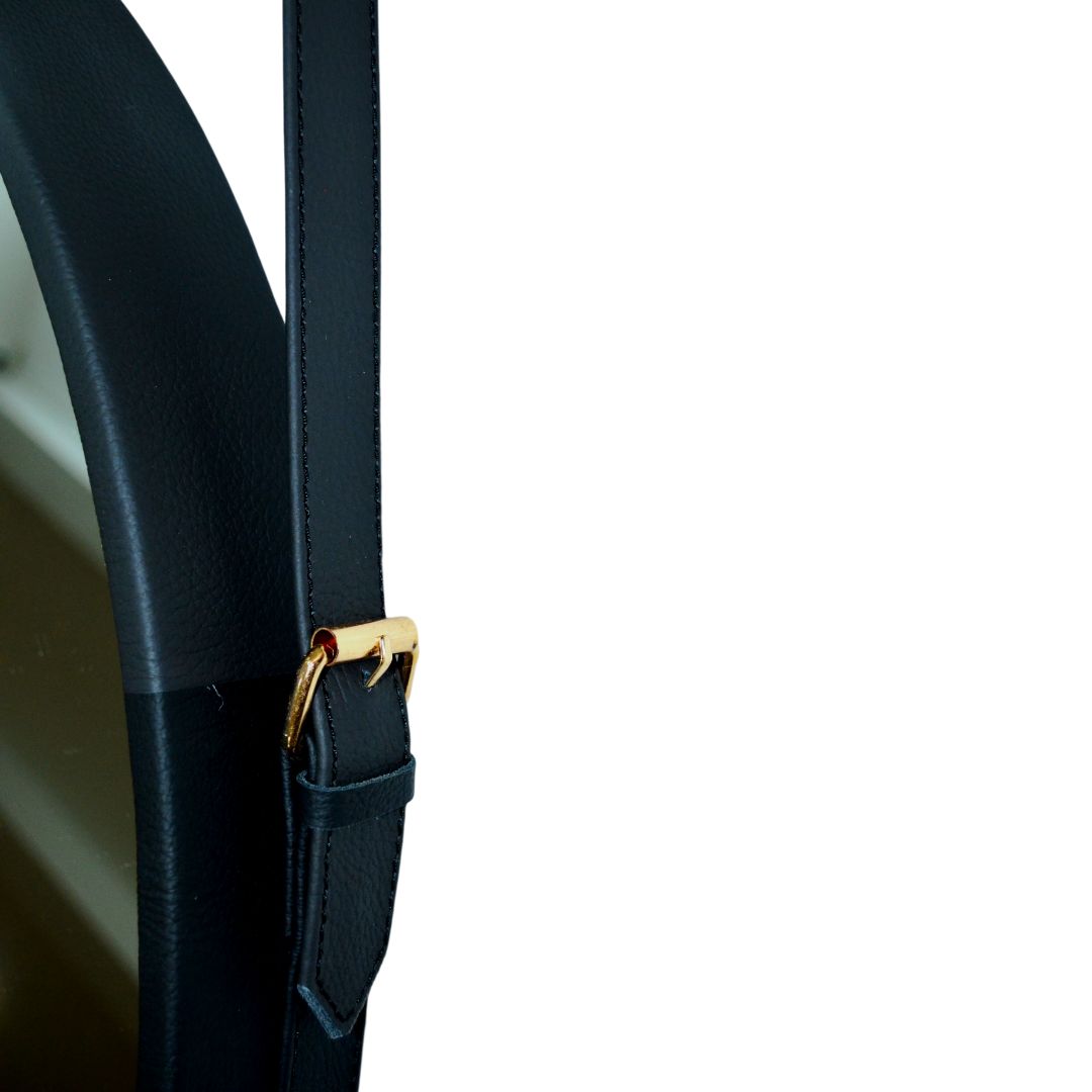"Leather strap hanging mirror with a minimalist frame for versatile wall decor."
