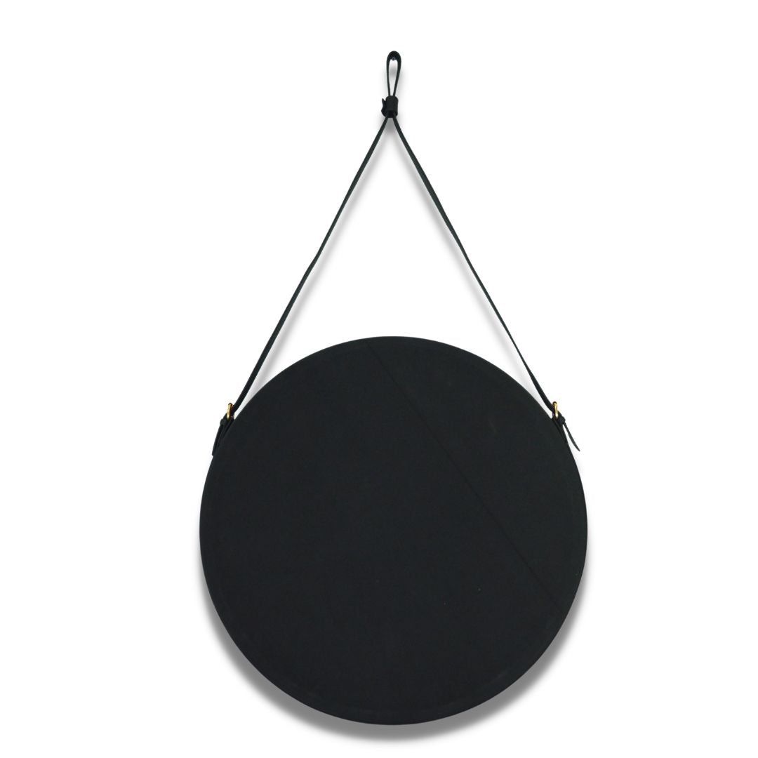 "Round vanity mirror with a leather-trimmed frame, perfect for bathrooms and bedrooms."