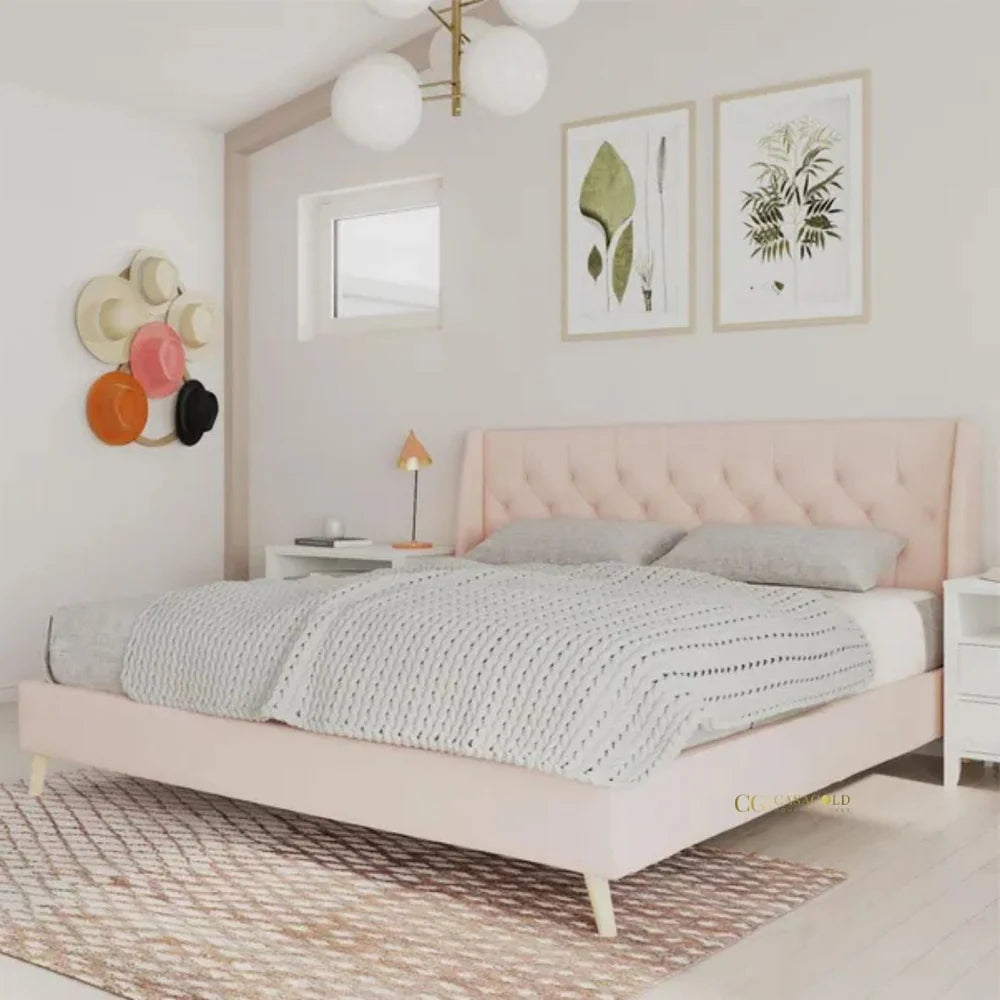 Pink upholstered bed with a gray blanket and pillows in a bedroom.