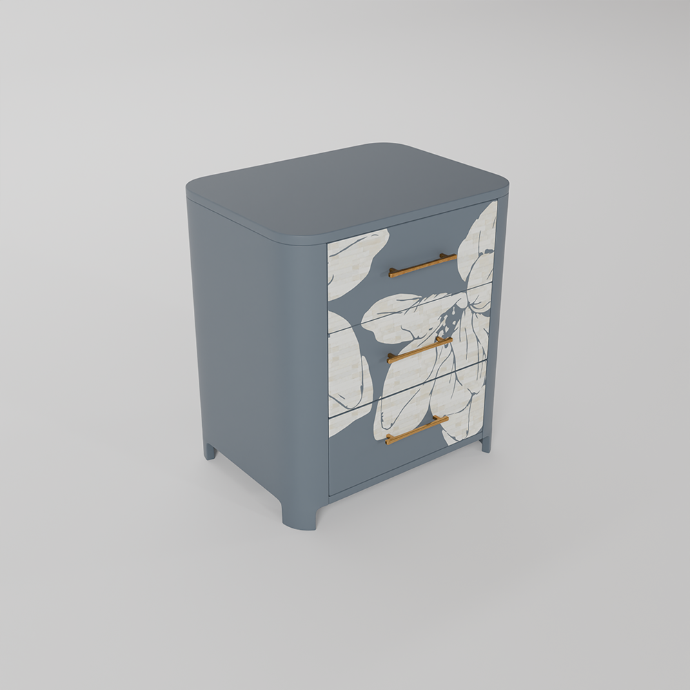 A modern three-drawer nightstand with a slate blue-gray finish, featuring a white floral pattern on the front doors and slim gold handles, shown on a neutral gray background.