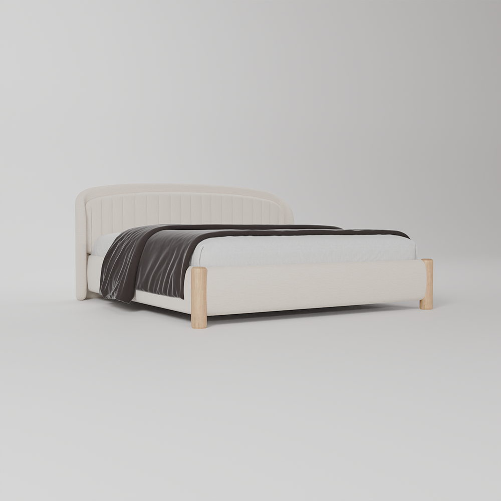 A modern platform bed with a light beige upholstered frame and light natural wood legs, styled with a white sheet and a dark gray textured throw blanket, set against a seamless light gray studio background.