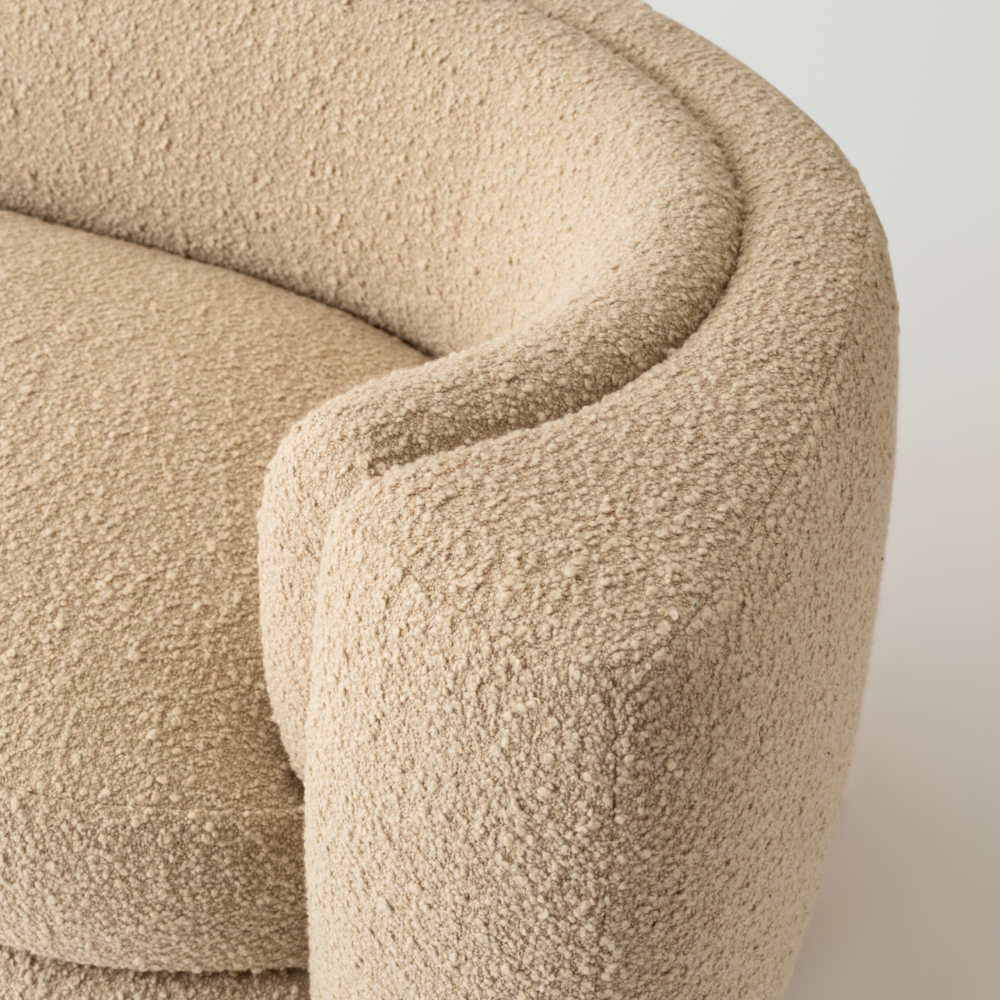 Close-up of a textured beige sofa on a plain background