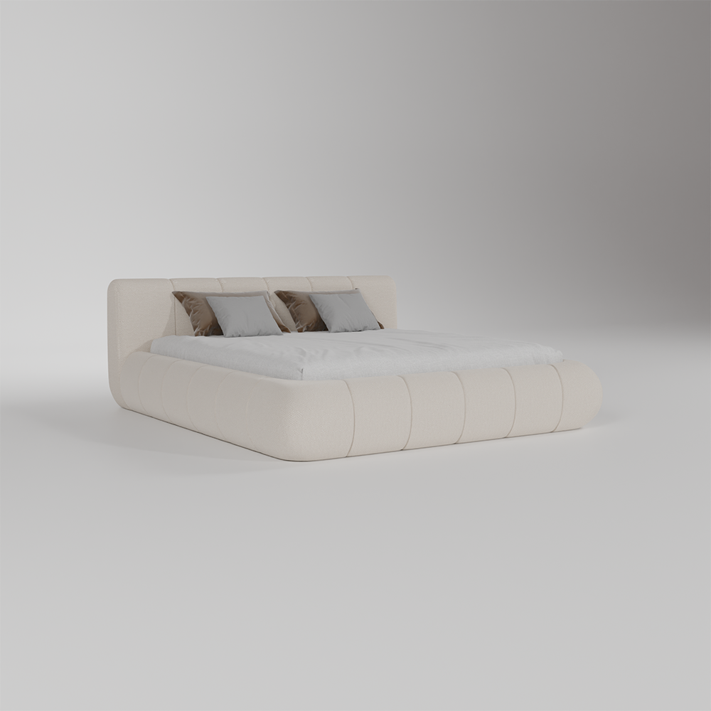 A modern low-profile platform bed with a padded headboard and footboard in a warm off-white or cream upholstery, styled with white bedding and three decorative pillows in gray and brown, set against a seamless light gray studio background.