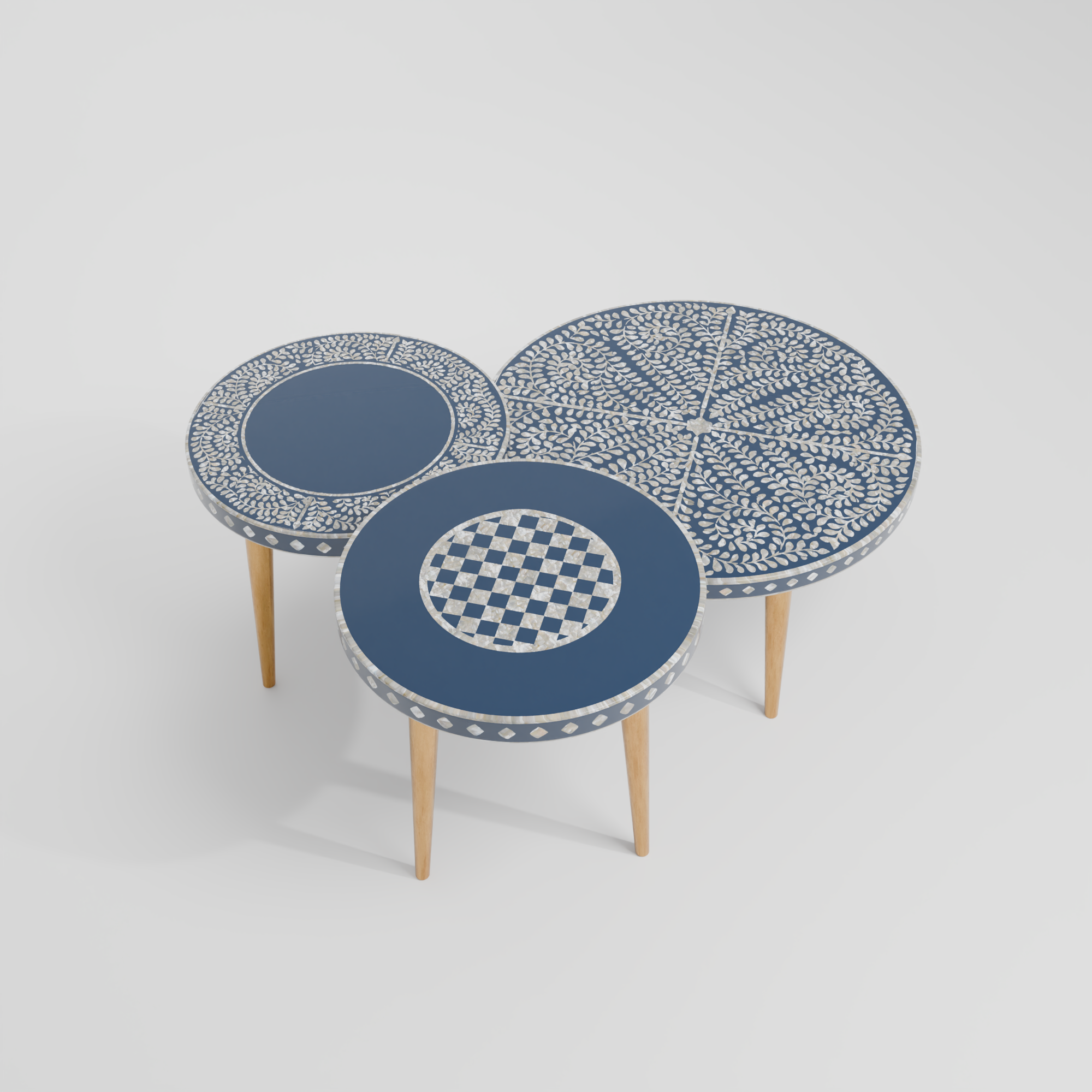 Three round side tables with patterned tops on a light gray background